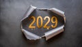 Ripped metallic paper revealling the year 2029 written in golden numbers on a gray background