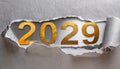 Ripped metallic paper revealling the year 2029 written in golden numbers on a silver background