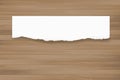 Ripped paper background on brown wood texture. Torn paper edge. Royalty Free Stock Photo