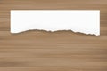 Ripped paper background on brown wood texture. Torn paper edge. Royalty Free Stock Photo