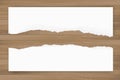 Ripped paper background on brown wood texture. Torn paper edge. Royalty Free Stock Photo