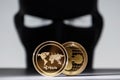 Ripple golden coins with a robber hacker wearing face mask