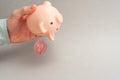 Ripple selling concept. Piggy bank for bitcoins. Cryptocurrency sell symbol. A man shake out bitcoin from money box on a gray back