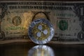 Ripple XRP crypto coin placed next to dollar in the dark background. Macro Shot.