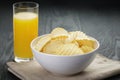 Rippled organic chips in white bowl with orange Royalty Free Stock Photo