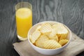 Rippled organic chips in white bowl with orange Royalty Free Stock Photo