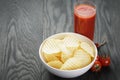 Rippled organic chips in white bowl wit tomato Royalty Free Stock Photo