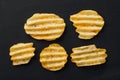 Rippled potato chips on black