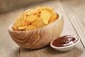 Rippled potato chips with paprika and bbq sauce in wooden bowl Royalty Free Stock Photo