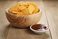 Rippled potato chips with paprika and bbq sauce in wooden bowl Royalty Free Stock Photo