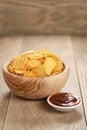 Rippled potato chips with paprika and bbq sauce in wooden bowl Royalty Free Stock Photo