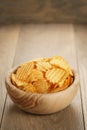 Rippled potato chips with paprika in wooden bowl Royalty Free Stock Photo