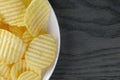 Rippled potato chips in white plate on wood table Royalty Free Stock Photo