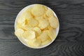 Rippled potato chips in white plate on wood table Royalty Free Stock Photo
