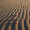 Rippled sand patterns, likely from wind, create a textured surface. Several colorful Royalty Free Stock Photo