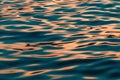 Rippled surface of blue sea water in sunset, orange and teal tones Royalty Free Stock Photo