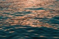 Rippled surface of blue sea water in sunset, orange and teal tones Royalty Free Stock Photo