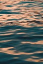 Rippled surface of blue sea water in sunset, orange and teal tones Royalty Free Stock Photo