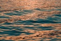 Rippled surface of blue sea water in sunset, orange and teal tones Royalty Free Stock Photo