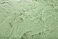 Rippled surface of clear water on light green background, top view Royalty Free Stock Photo