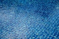 Rippled water reflects blue tiles under sunlight, forming a clear grid pattern with light movement creating layered textures Royalty Free Stock Photo