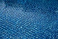 Rippled water reflects blue tiles under sunlight, forming a clear grid pattern with light movement creating layered textures Royalty Free Stock Photo