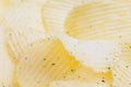 Rippled yellow potato chips closeup with blur, background. Royalty Free Stock Photo