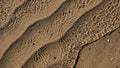 Rippling water flows over sandy beach patterns creating undulating lines Royalty Free Stock Photo