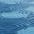 Rippling water surface featuring concentric circles created by raindrops. The image Royalty Free Stock Photo