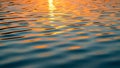 Rippling water surface reflecting a sunset with hues of orange and blue Royalty Free Stock Photo