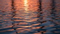 Rippling Water Surface Reflecting Warm Orange Sunset Light Creating Abstract Patterns Keywords: water, surface Royalty Free Stock Photo