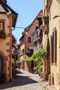 RIQUEWIHR, FRANCE - JULY 17, 2017: Picturesque street with traditional colorful houses in Riquewihr village on alsatian wine route Royalty Free Stock Photo