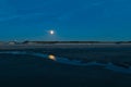 Rise of the full moon over the beach during blue hour Royalty Free Stock Photo
