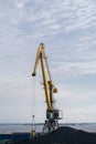 Rise tower crane over coastal terminal as charcoal is being loaded onto trains for transport Royalty Free Stock Photo