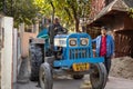 Rishikesh, India - Two Indian men guide a tractor through the narrow streets of town Royalty Free Stock Photo