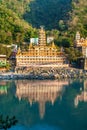 RISHIKESH, INDIA -Noveber 2012: Tera Manzil Temple view from the other Ganga bank with a mirror reflection in the water. Royalty Free Stock Photo