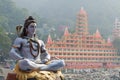 Statue of Shiva sitting in meditation on the riverbank of Ganga in Rishikesh, Tera Manzil Temple, Trayambakeshwar in background Royalty Free Stock Photo