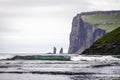 Risin and Kellingin sea stacks in the distance, with a big Wave approaching Tjornuvik bay, Streymoy, Faroe Islands (Faroes&#