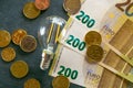 Rising electricity prices in Europe.Saving electricity.Electricity cost. Light bulb, euro banknotes and coins on black