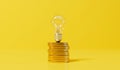 Rising energy cost concept. Light bulb on top of a stack of gold coins. 3D Rendering