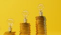 Rising energy cost concept. Light bulb on top of a stack of gold coins. 3D Rendering