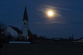 Rising full moon next to a catholic church Royalty Free Stock Photo