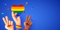 Rising multiethnic Hands celebrate pride month on LGBT rainbow flag background. People's rights movement, diversity concept