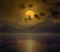 Full moon in dark night sky with reflection in water Royalty Free Stock Photo