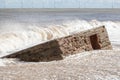 Rising sea level. Wave flooding beach and engulfing historical W