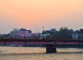 Rising Sun above City with Orange Sky and Bridge over Holy River Ganges - Ganga - Har ki Paudi, Haridwar, Uttarakhand, India Royalty Free Stock Photo