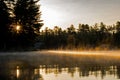 Rising Sun Breaks Through The Trees On A Misty Canadian Lake Royalty Free Stock Photo