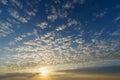 Rising sun over blue sky with cirrocumulus clouds Royalty Free Stock Photo