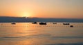 Rising sun over grey clouds, adriatic ocean with boats, dreamy scenery
