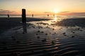 Rising tide on a scenic beach with poles and piles on Sylt island Gemany during a beatiful sunrise Royalty Free Stock Photo